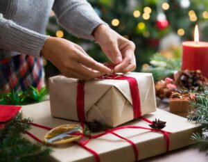 manos envolviendo regalo con fondo de navidad para consumo responsable